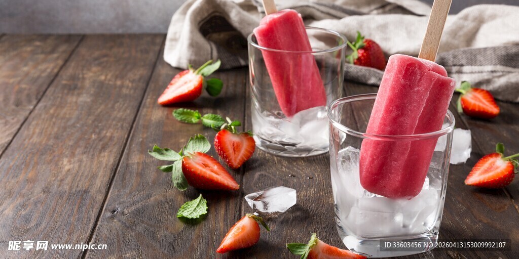草莓冰棍置于玻璃杯旁
