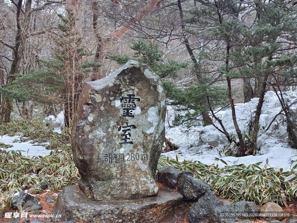 雪覆山林中的古朴石碑