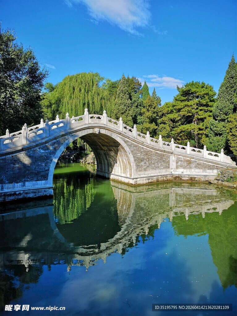 中式石拱桥倒映碧水蓝天