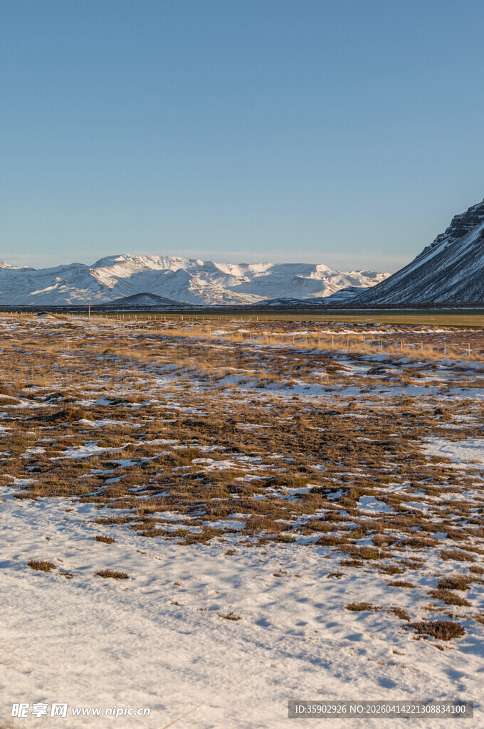 雪覆旷野与远处雪山景观