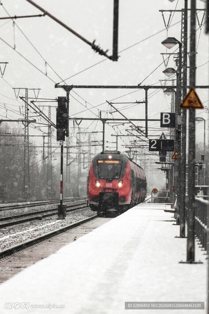 雪中铁轨上行驶的红色列车