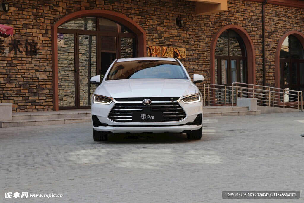 白色轿车停于特色建筑前