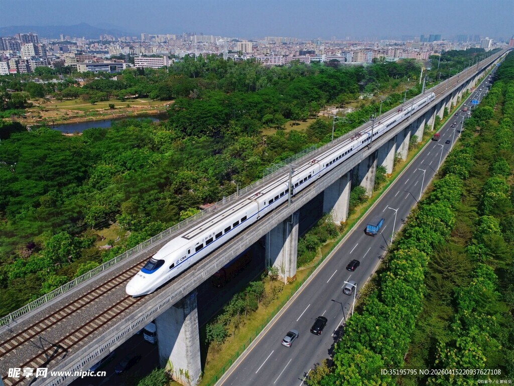 高铁穿行于公路与绿野间