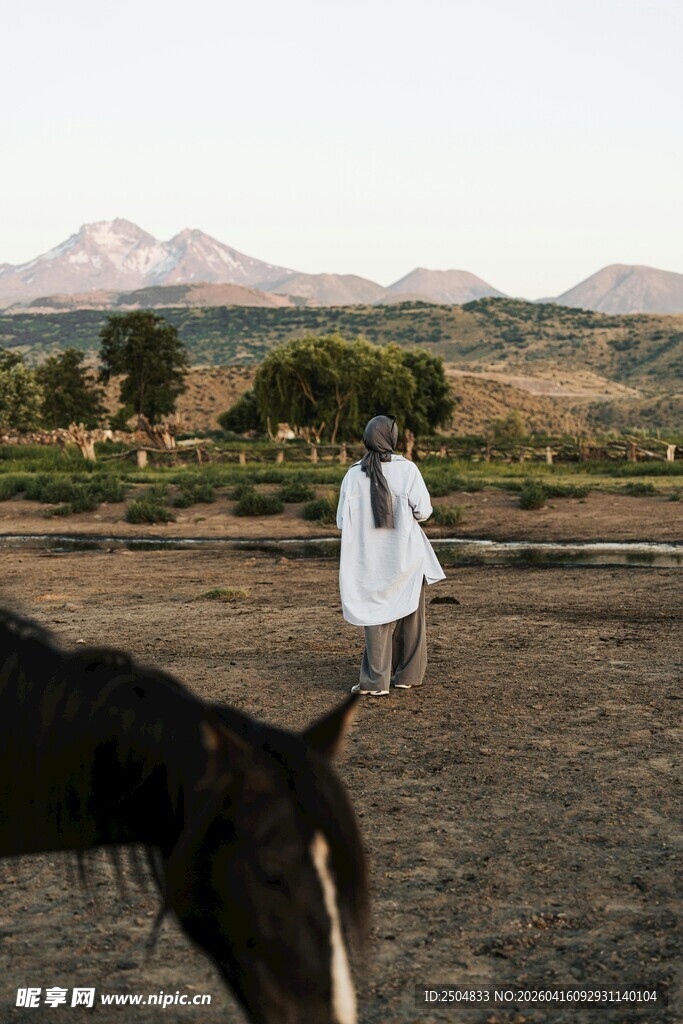 田野中身着白衣的行人和马