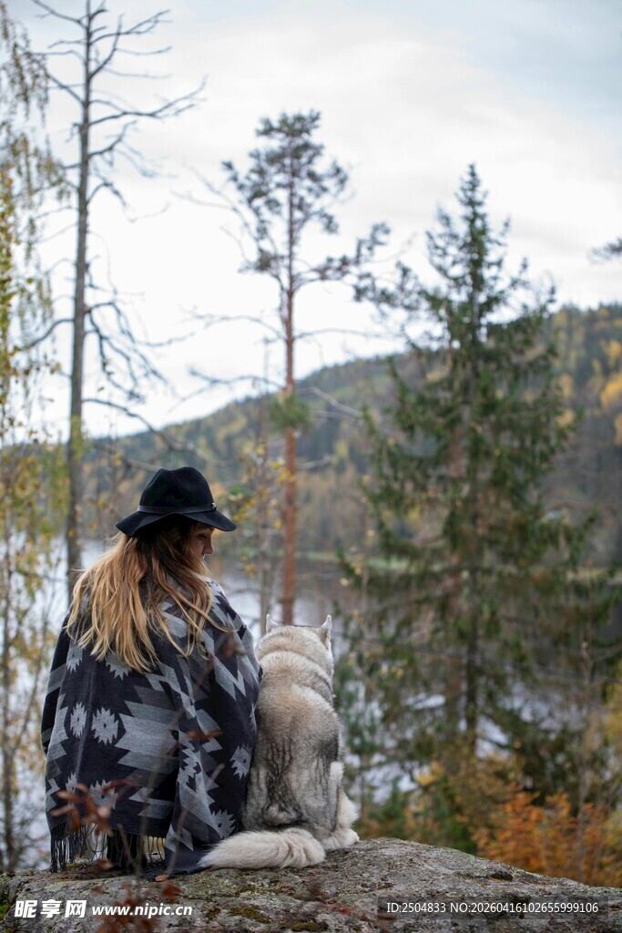 女子携犬赏湖畔山林美景