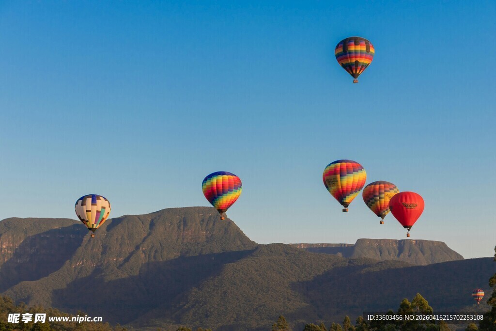 蓝天山脉间的多彩热气球