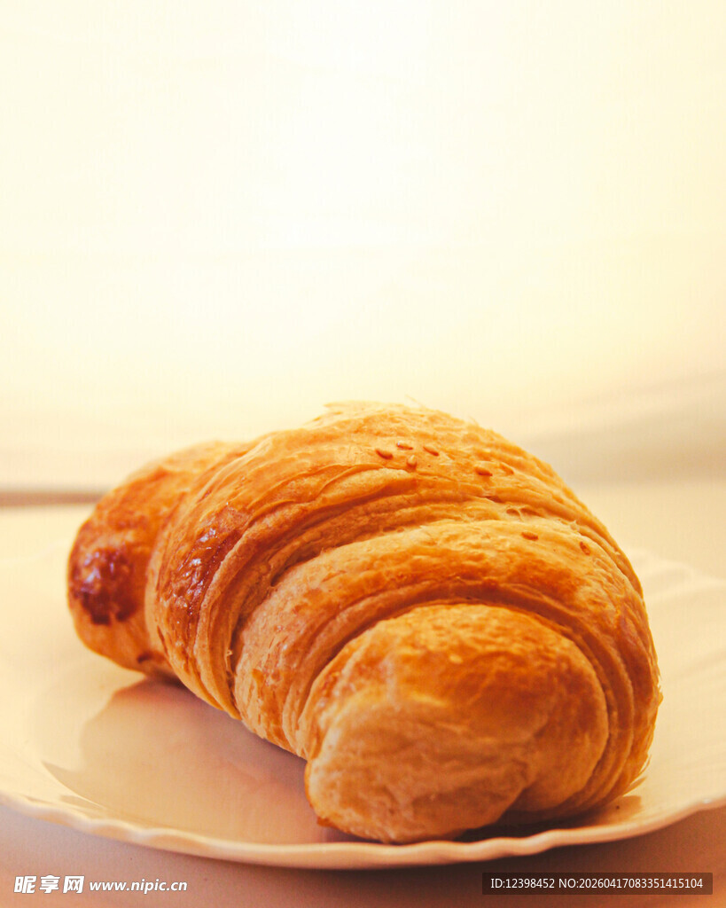 美味牛角面包置于白盘上