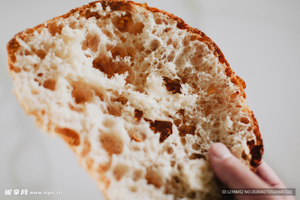 手捧美味孔洞丰富的面包