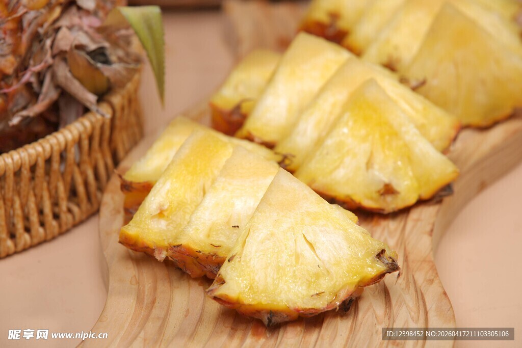 新鲜切块菠萝摆于木盘上