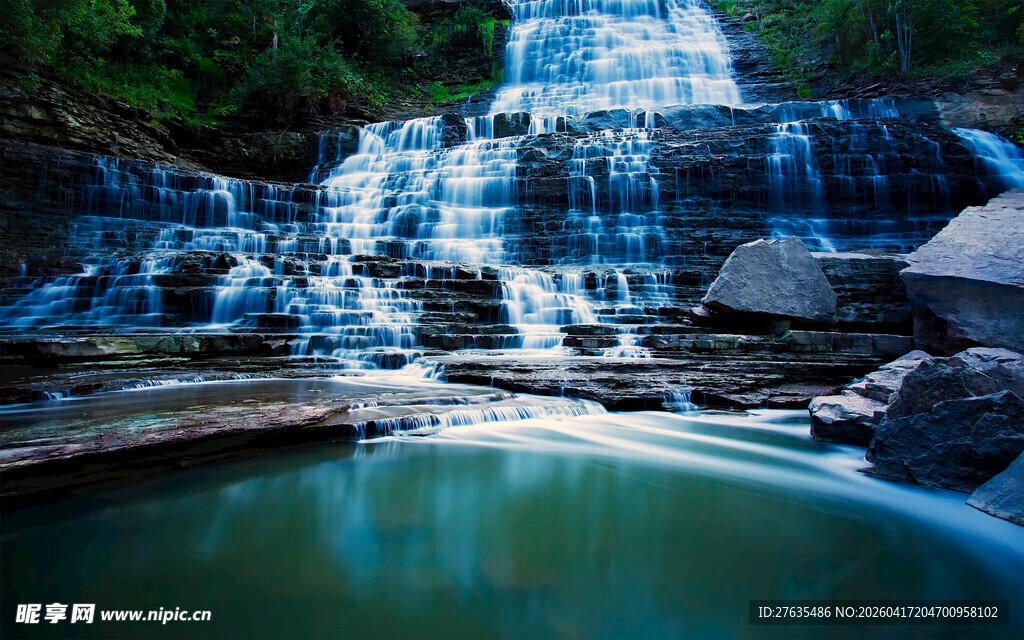 山间清澈瀑布下的碧绿潭水