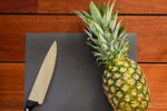 砧板上的菠萝与锋利刀具