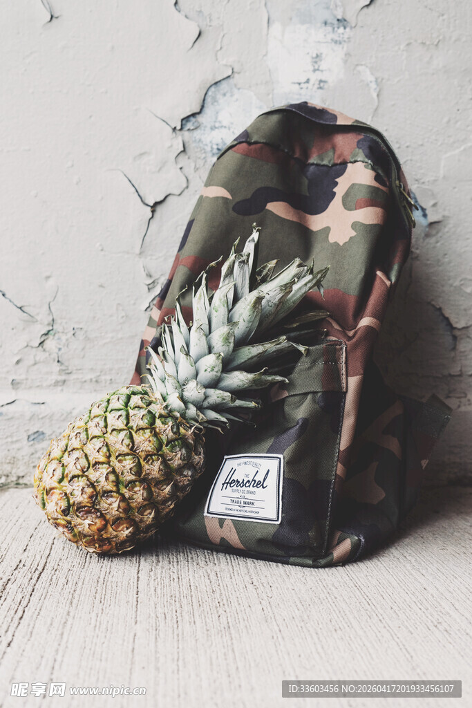 迷彩背包旁的新鲜菠萝