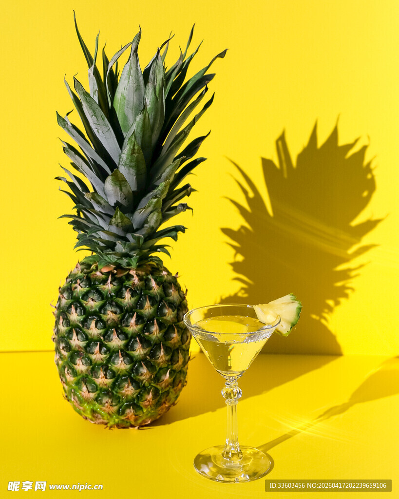 黄色背景的菠萝与鸡尾酒杯