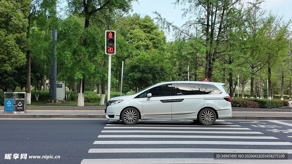 白色轿车行驶在城市道路