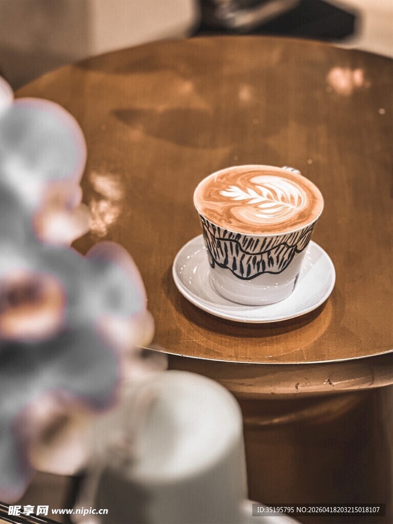 精致拉花咖啡置于圆桌上