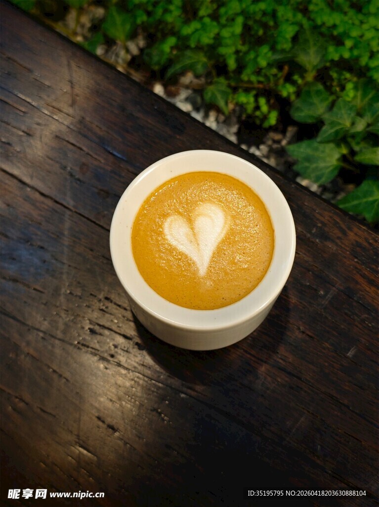 木桌上的心形拉花咖啡