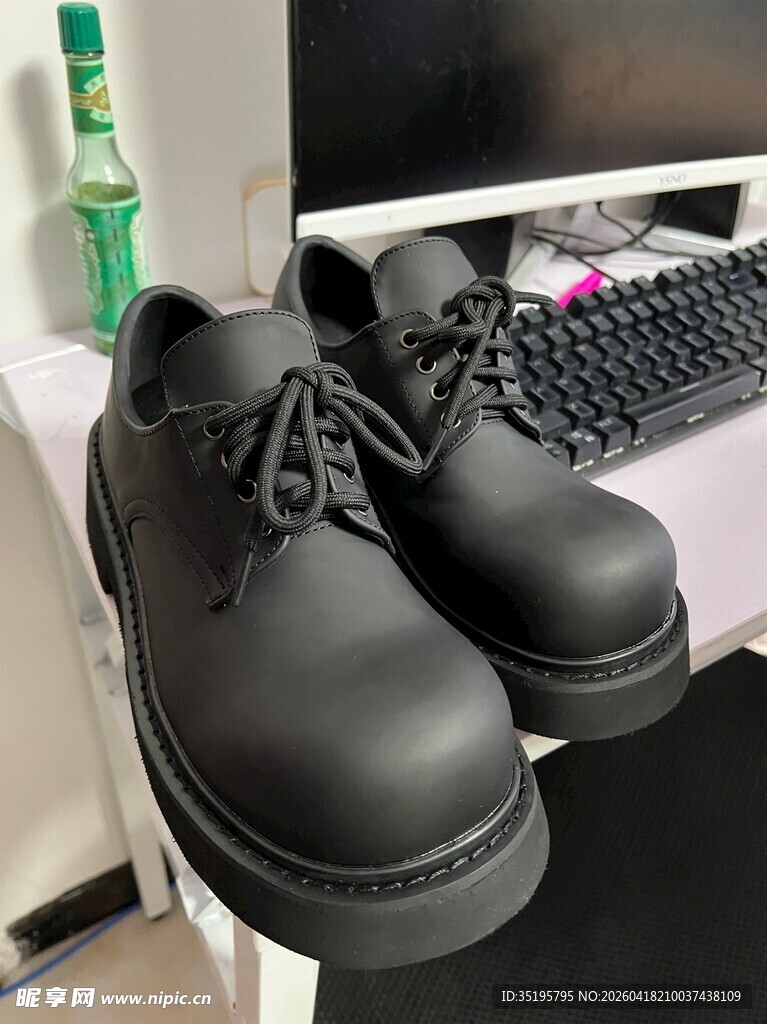 黑色厚底皮鞋置于桌上