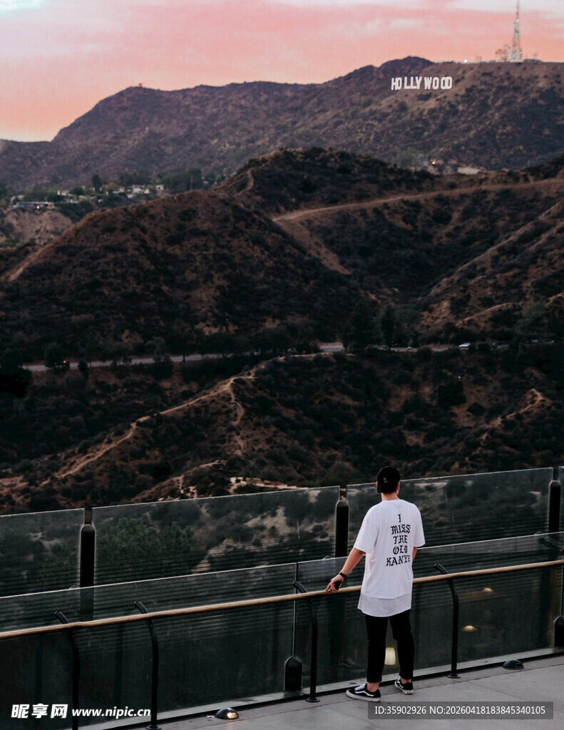 男子眺望远处山丘与城市