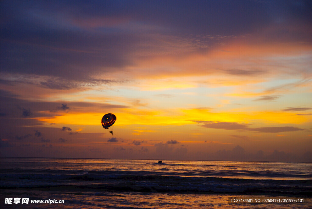 海边日落时的浪漫滑翔伞