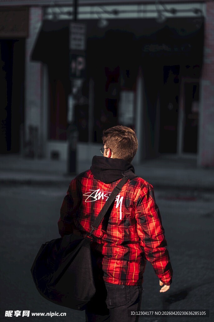 背着包行走的红衣男子