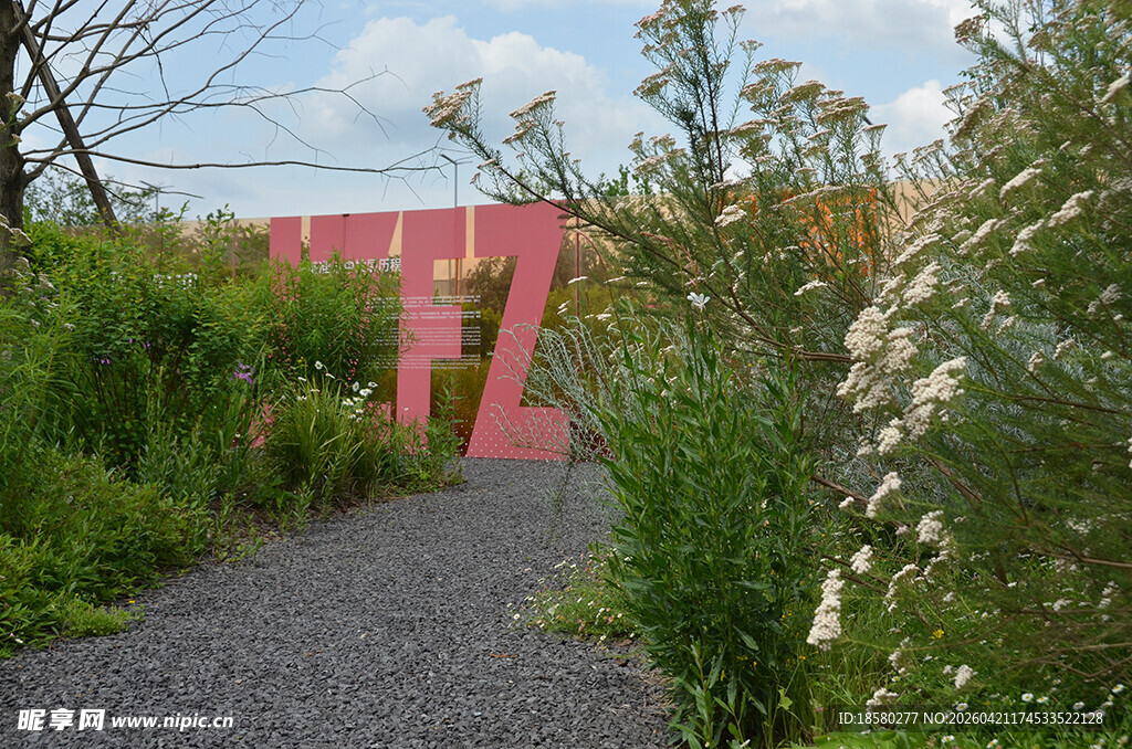 粉色建筑旁的绿植小径