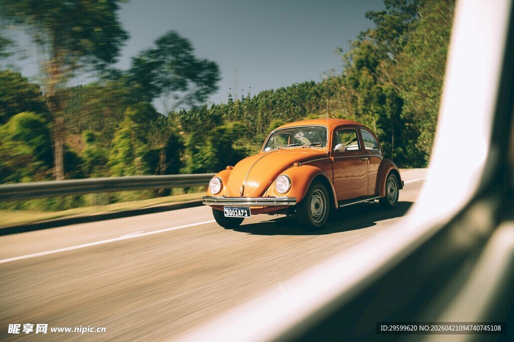 公路上行驶的复古橙色汽车