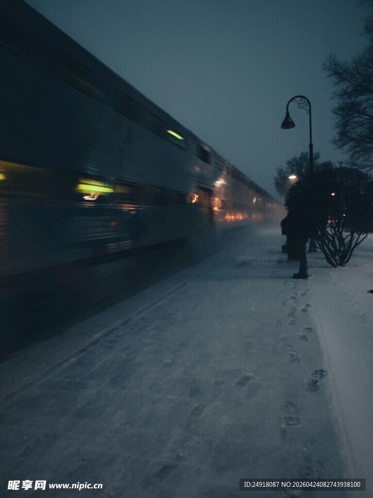 雪夜站台旁的行驶列车