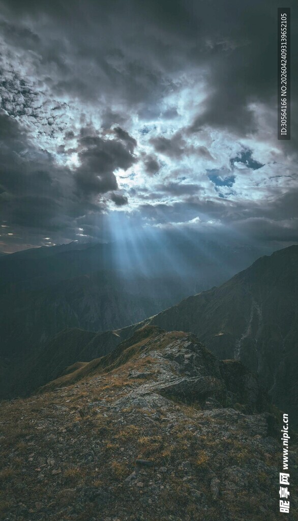 乌云下穿透光芒的山间景色