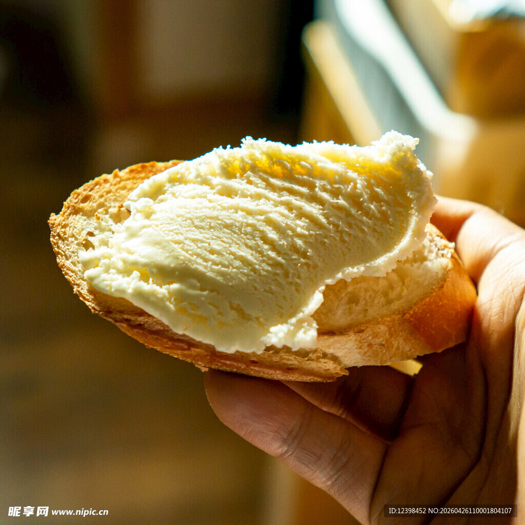 手拿涂有奶油的面包片