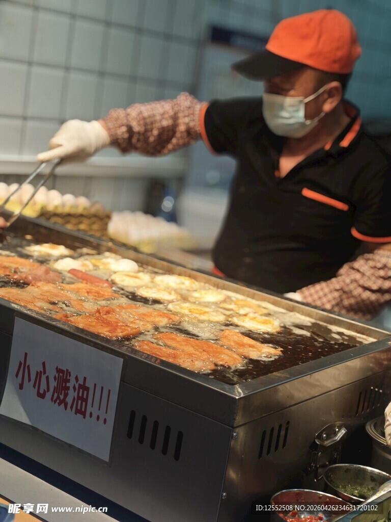 街头烤肠摊主忙碌烤制中