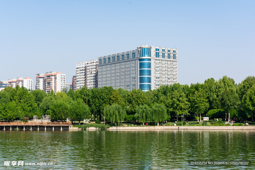 湖畔高楼与葱郁绿树景观