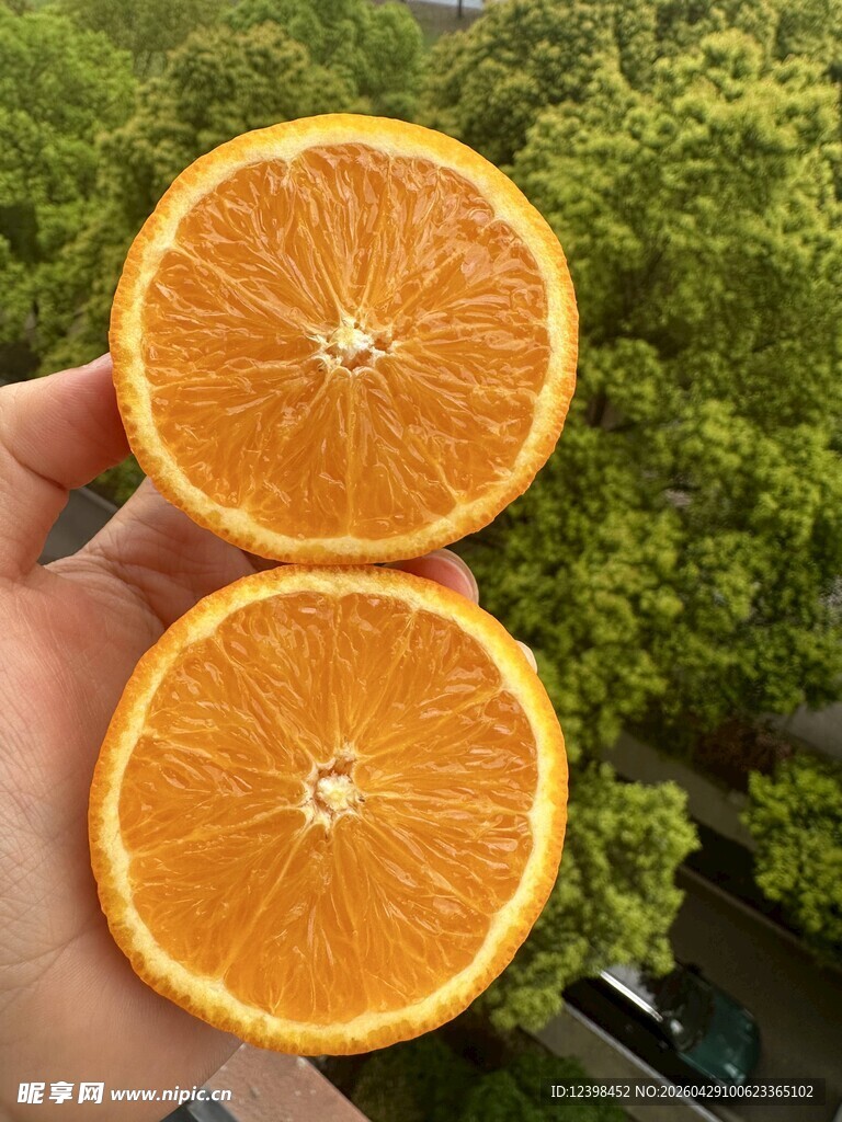 手捧两半新鲜橙子