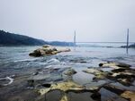 海边礁石与远处桥梁景观