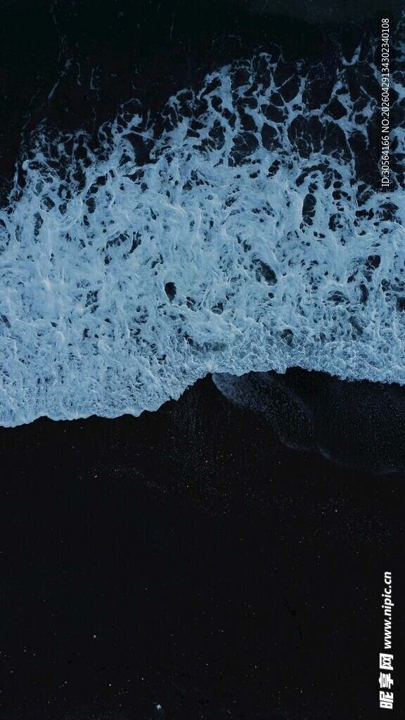 海浪拍打岸边的黑色礁石