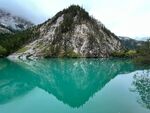 碧绿湖水旁的巍峨山峰
