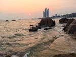 海边日落与远处高楼美景