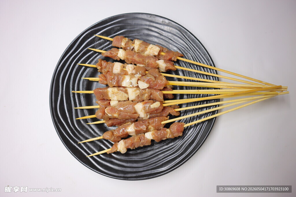 美味鸡肉串摆放在黑盘上