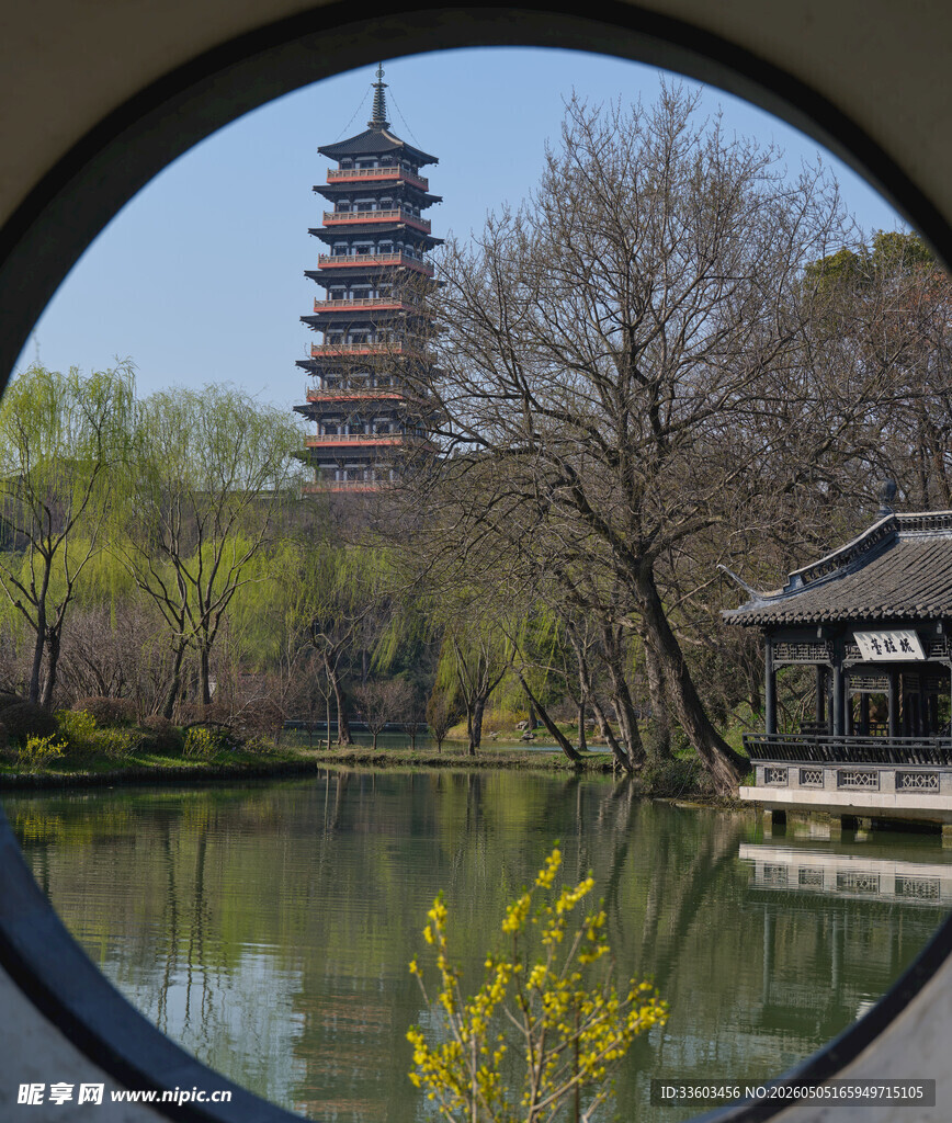 透过圆窗观古塔湖景