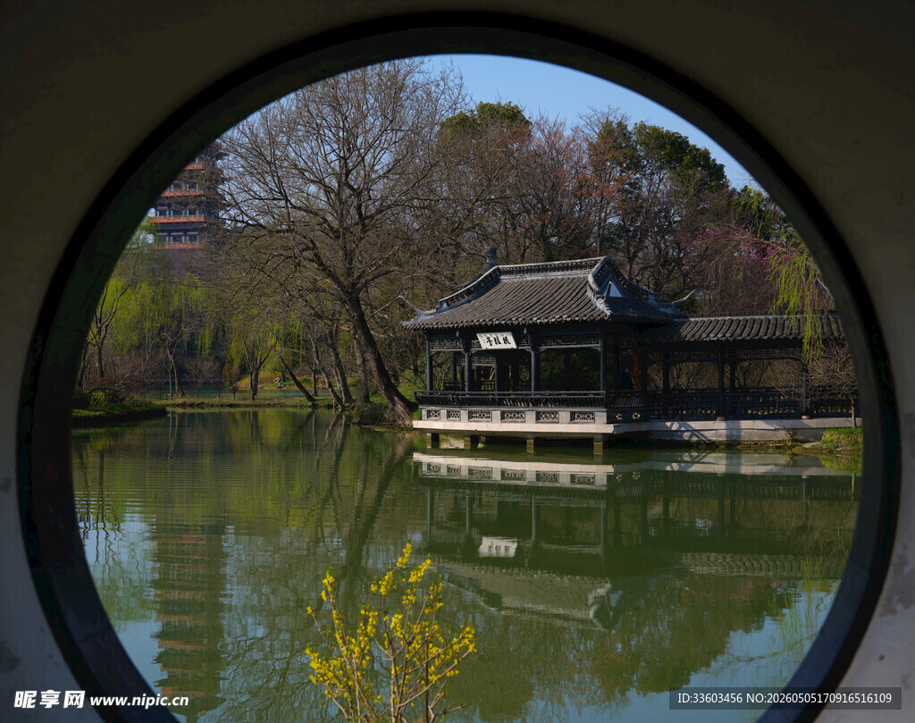 透过圆窗赏中式湖景建筑
