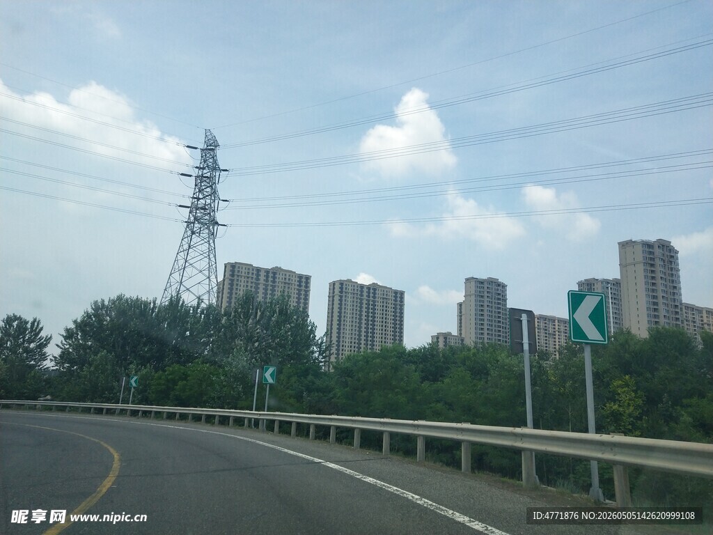 公路旁的城市与输电塔景观