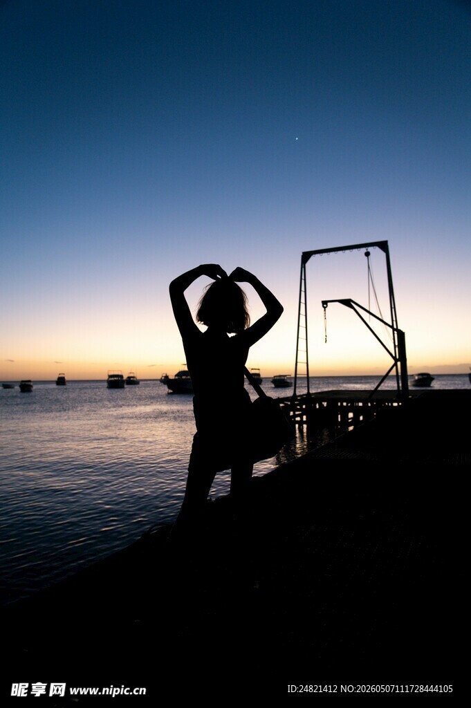 海边女子夕阳下的剪影姿态