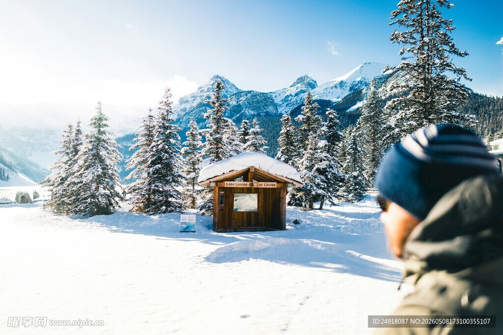 雪中山间小屋前的旅人