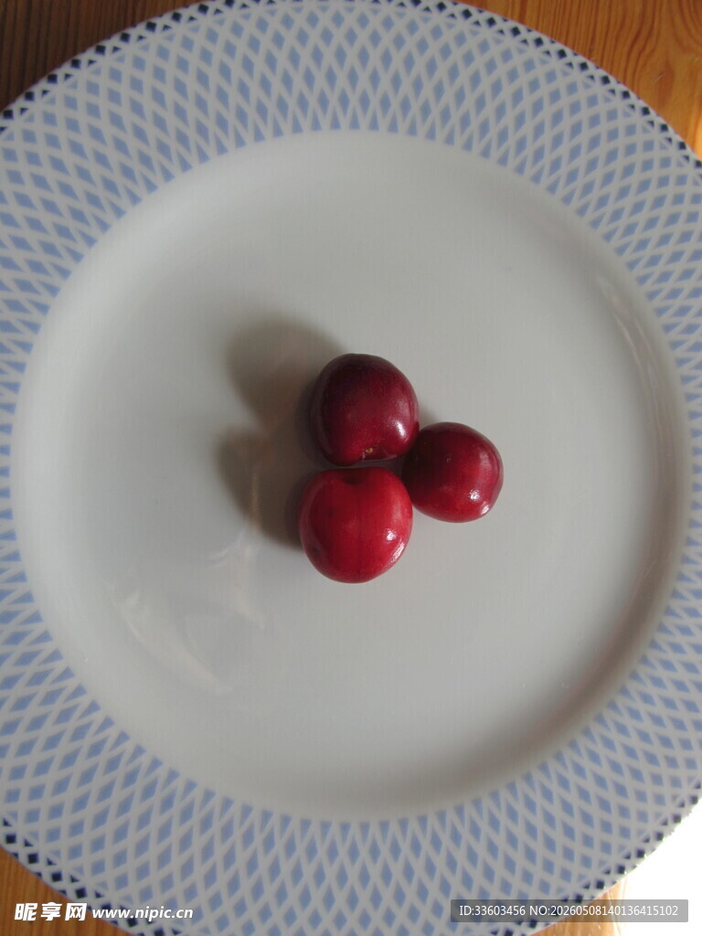 盘中三颗鲜红樱桃