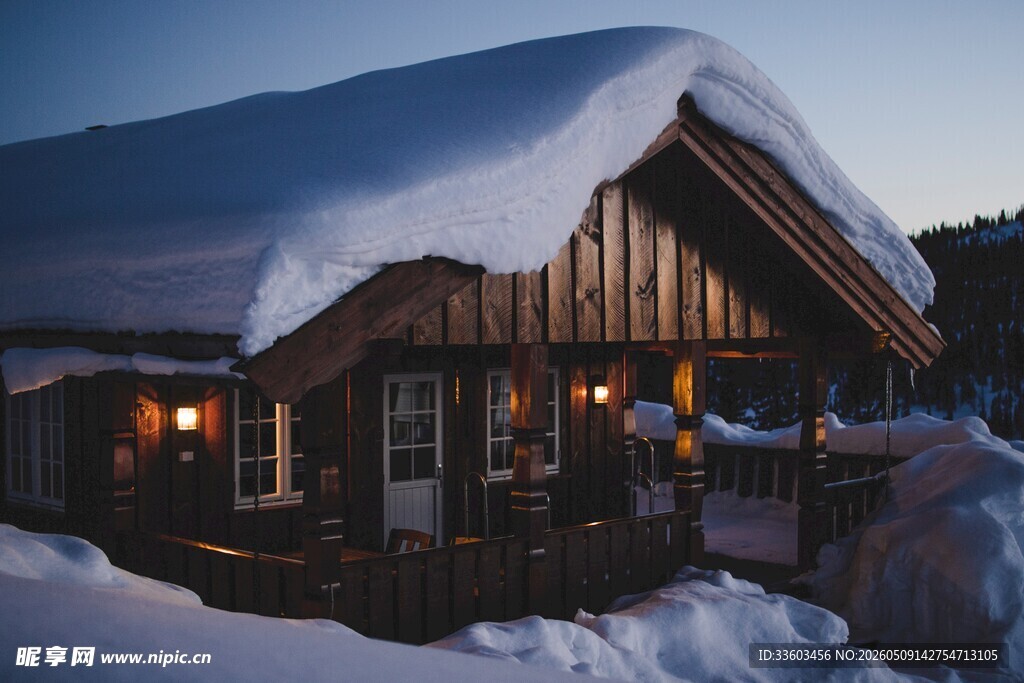 雪覆木屋暖灯点亮冬夜