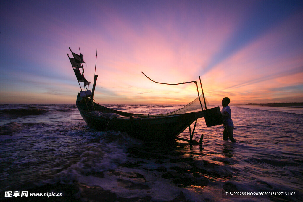 夕阳下的海边渔船与身影
