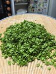 竹席上的鲜嫩绿色碎菜叶