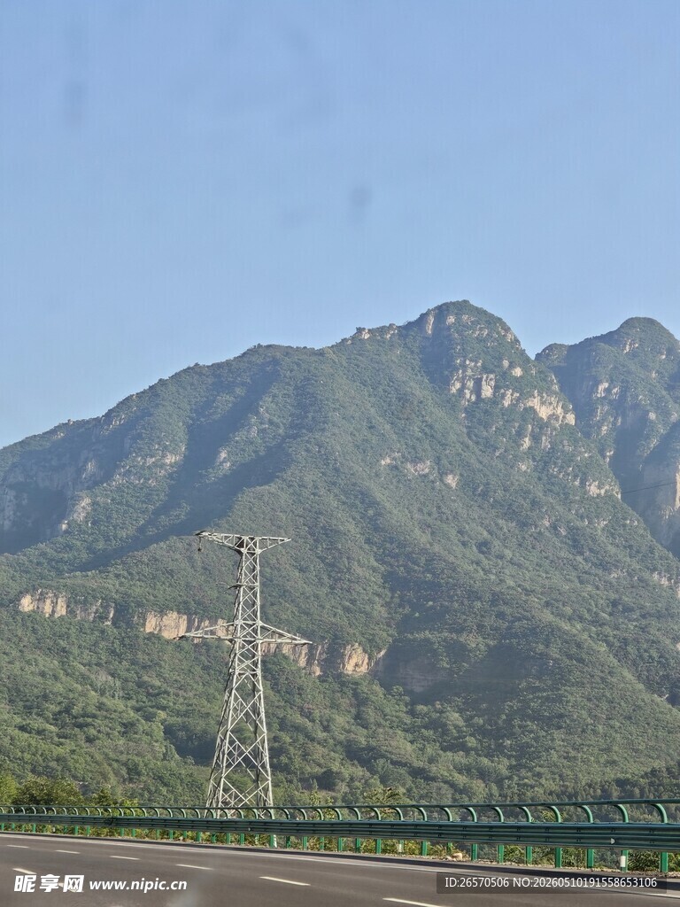 山间公路旁的高耸输电塔