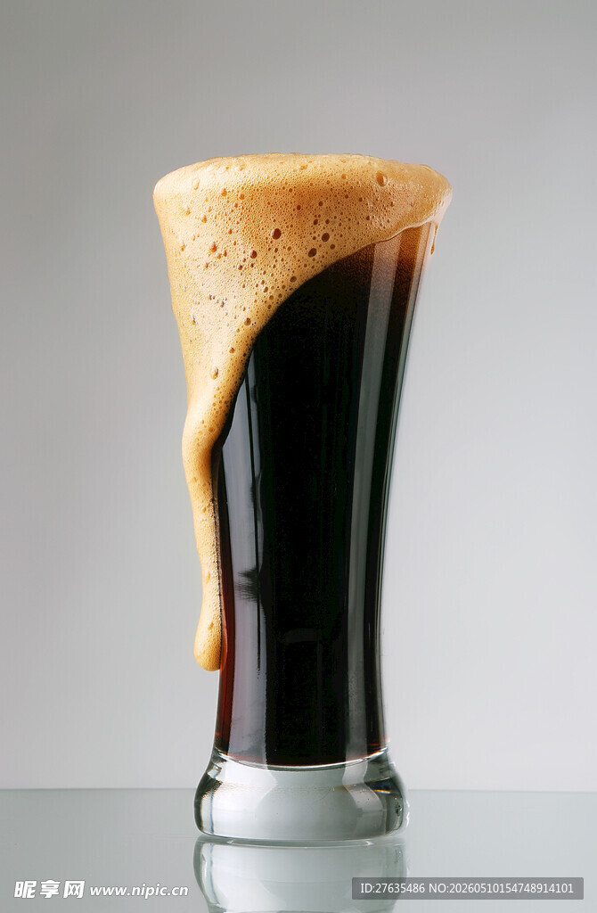 满溢的深色泡沫啤酒杯