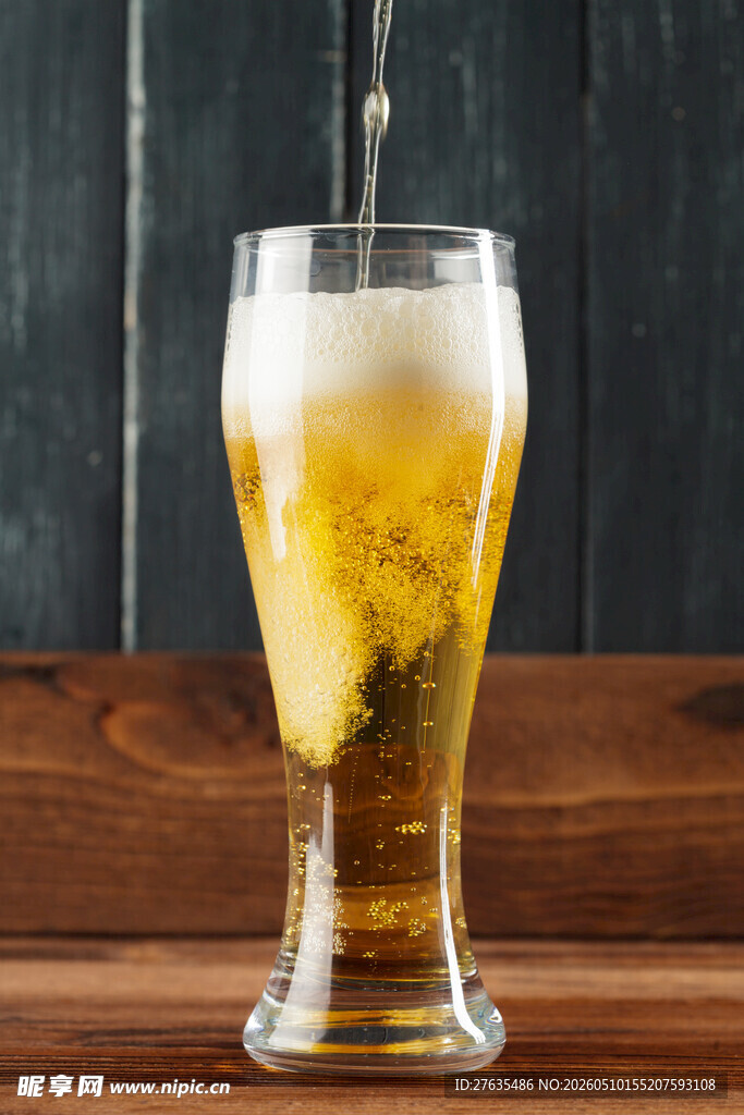 木桌上的一杯冒泡啤酒