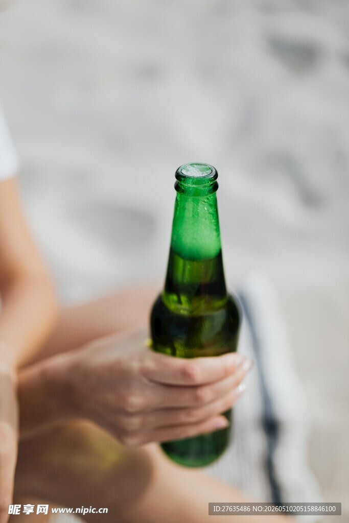 手持绿啤酒瓶的惬意时刻
